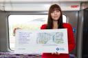 Photography student Inga Tenyte holds an Elizabeth line poster with her artwork on
