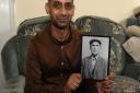 Asif Shakoor holding a photograph of his Grandfather Mahomed Gama.