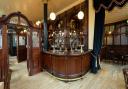 The Boleyn Tavern's main bar complete with wooden screens based on an original which remains and includes a pot man's door through which glass collectors would pass.