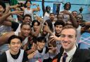 NewVIc teacher, William Twigg celebrates with students, after getting his award from Basketball England