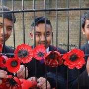 Stratford School Academy pupils fasten poppies to the gate