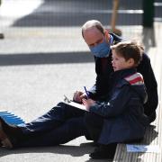 The Duke of Cambridge talks with a child in the playground during a visit to School 21 in Stratford.