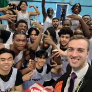 NewVIc teacher, William Twigg celebrates with students, after getting his award from Basketball England