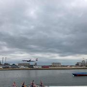 A plane lands at London City Airport across the water from Royal Albert Dock in Newham CREDIT: Robert Firth