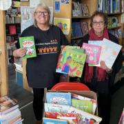 Paula Blake collects a donation from Newham Bookshop's Vivian Archer